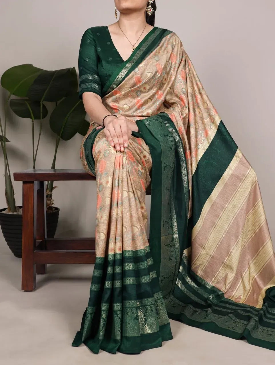 Full view of model sitting wearing green blouse and silk saree
