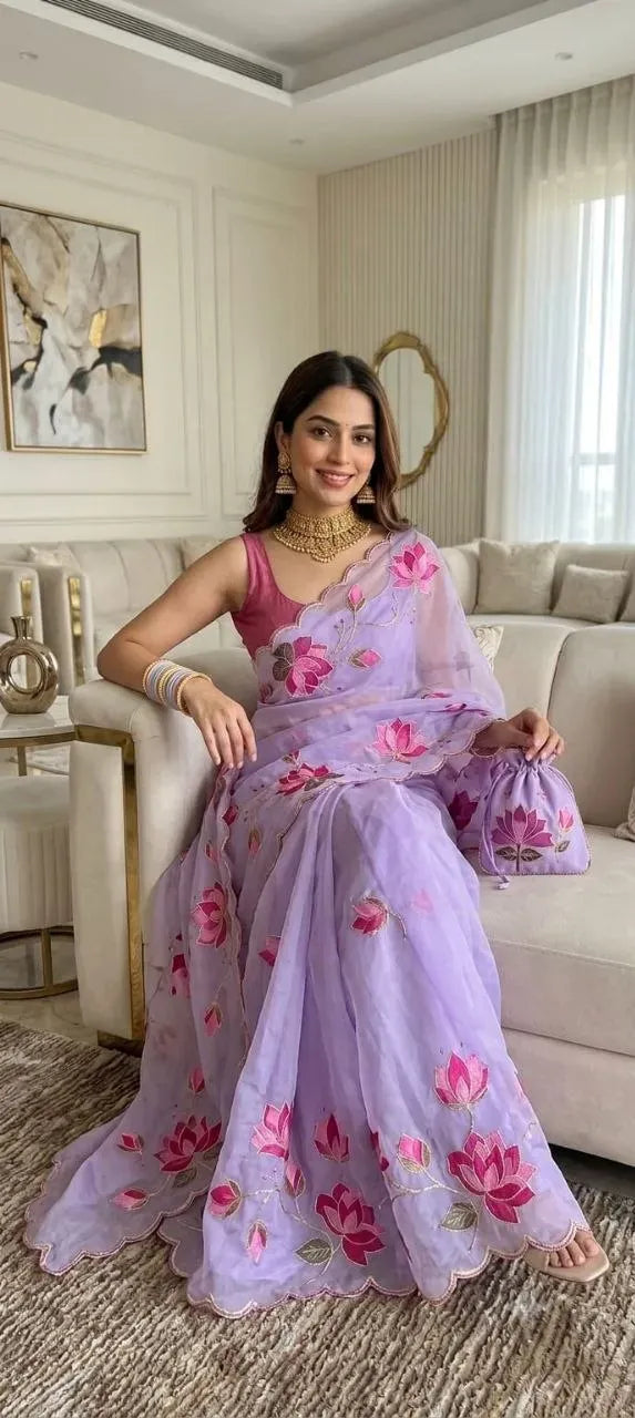 Model wearing pastel purple teby silk saree with matching potli bag