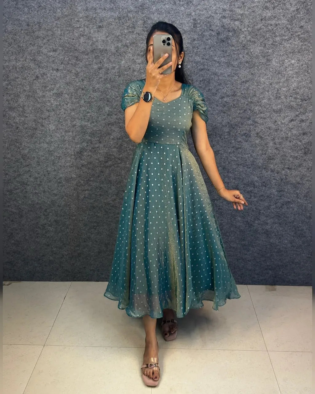 Model wearing teal green dual tone tissue midi gown with white jari butti work and puffed sleeves