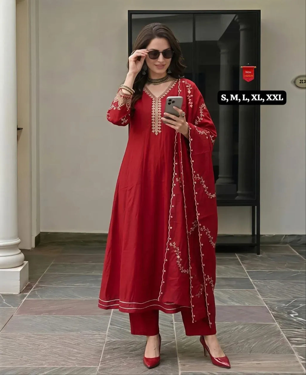 Model wearing red Vichitra silk kurti set with embroidery holding phone
