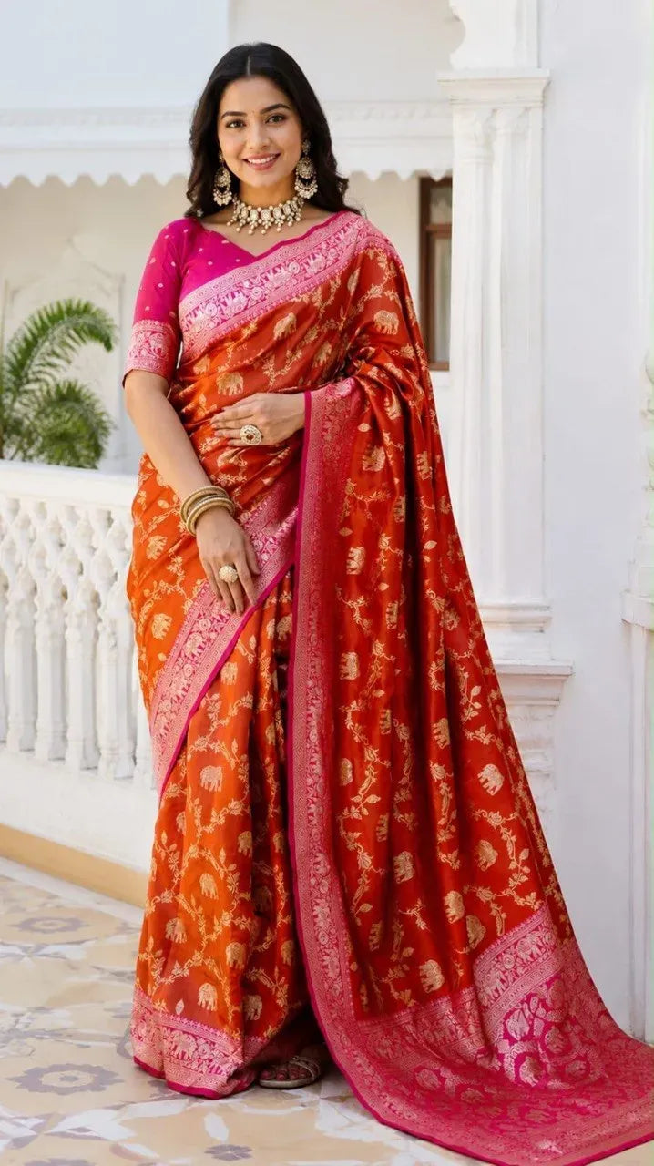 Model wearing orange Banarasi silk saree with pink border and intricate zari work