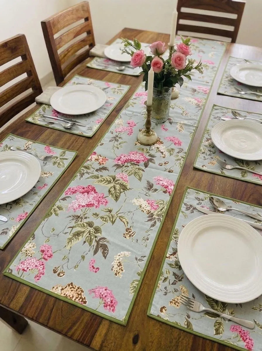 Sage green casemat table runner and placemats set with pink floral print on wooden table