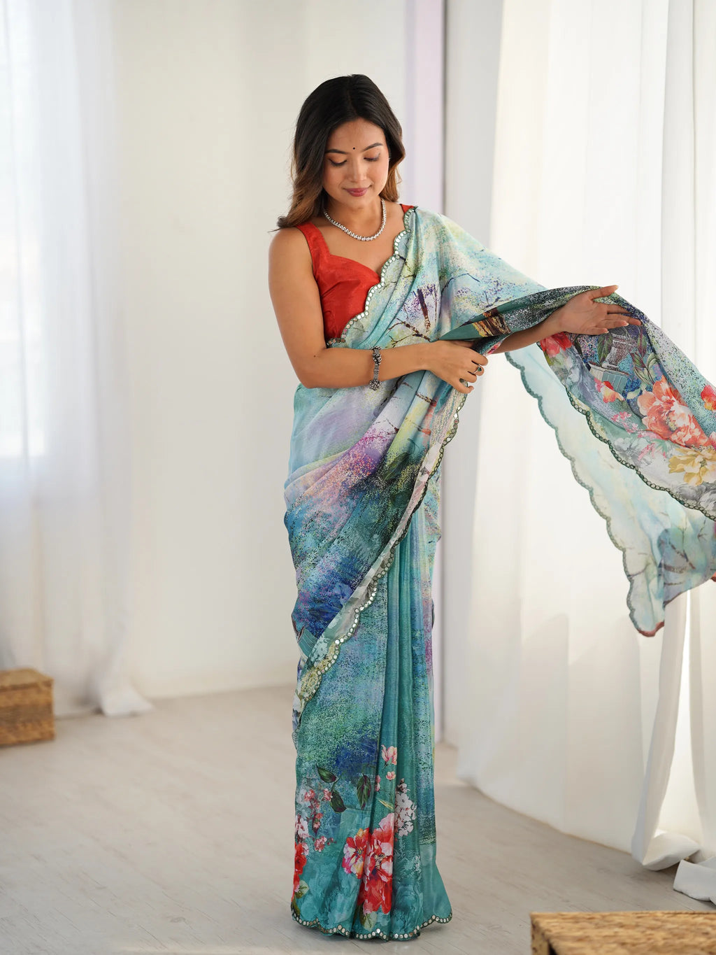 Full length front view of model wearing blue printed chinnon saree with red blouse
