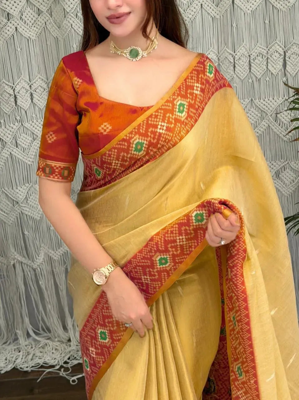 Model wearing yellow cotton silk saree with red and gold zari border
