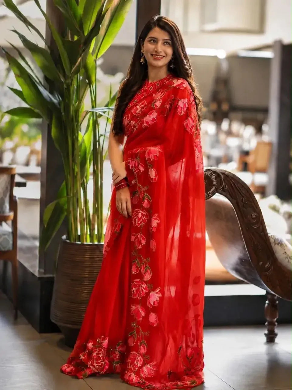 Model wearing red georgette silk saree with floral print and handwork