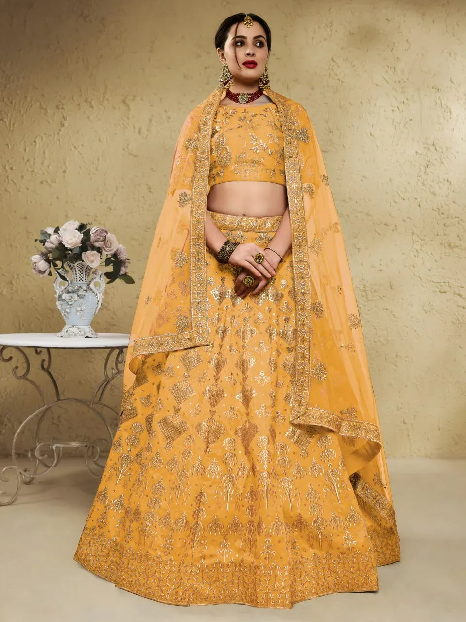 Model wearing golden mustard art silk lehenga choli with net dupatta