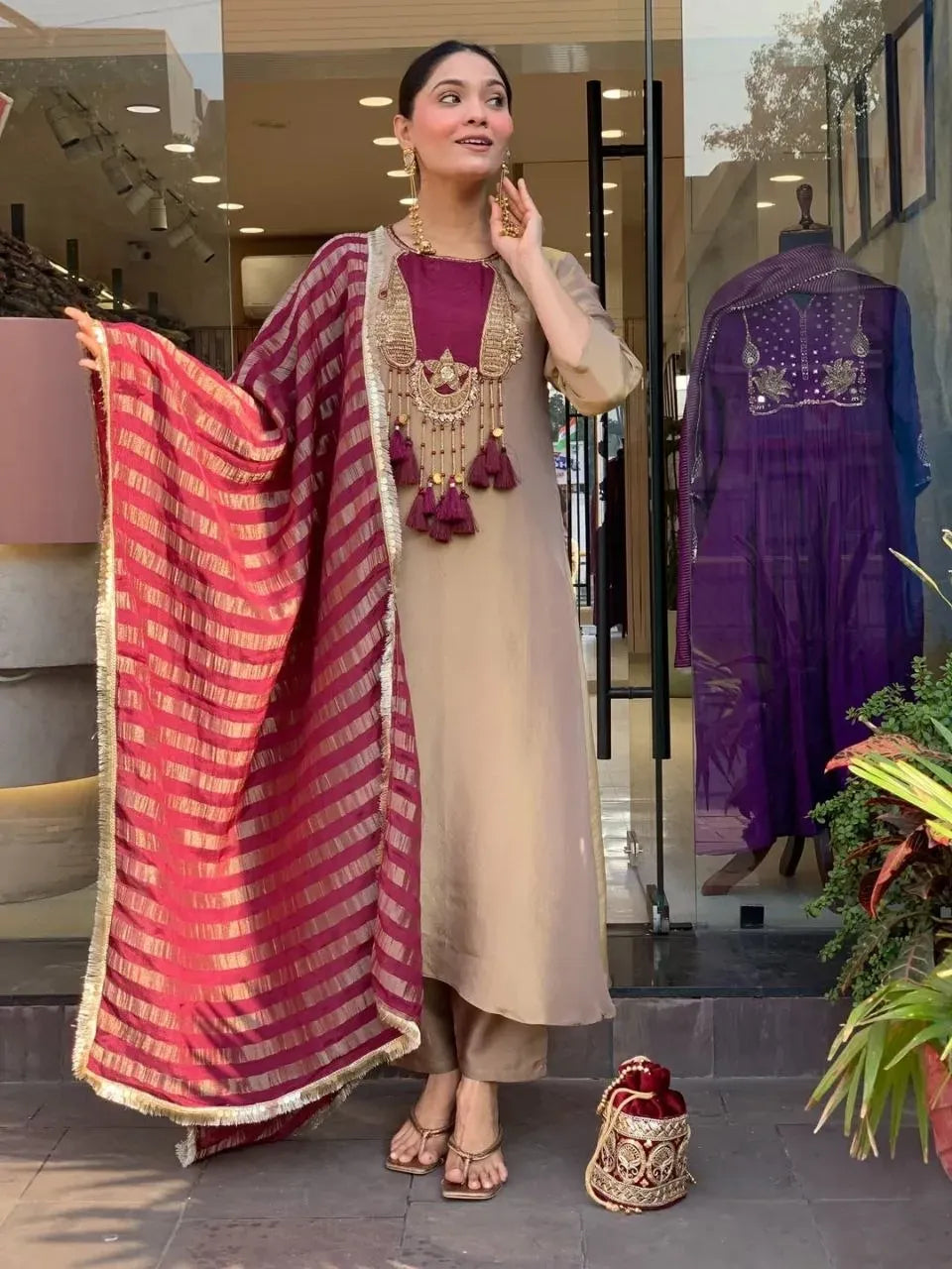 Full length front view of woman in beige kurti set with wine dupatta and tassels