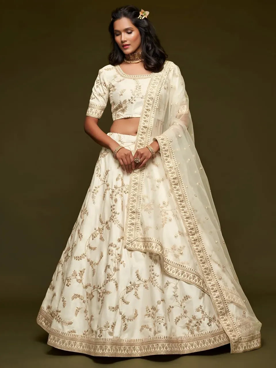 Model wearing ivory white embroidered lehenga choli with net dupatta