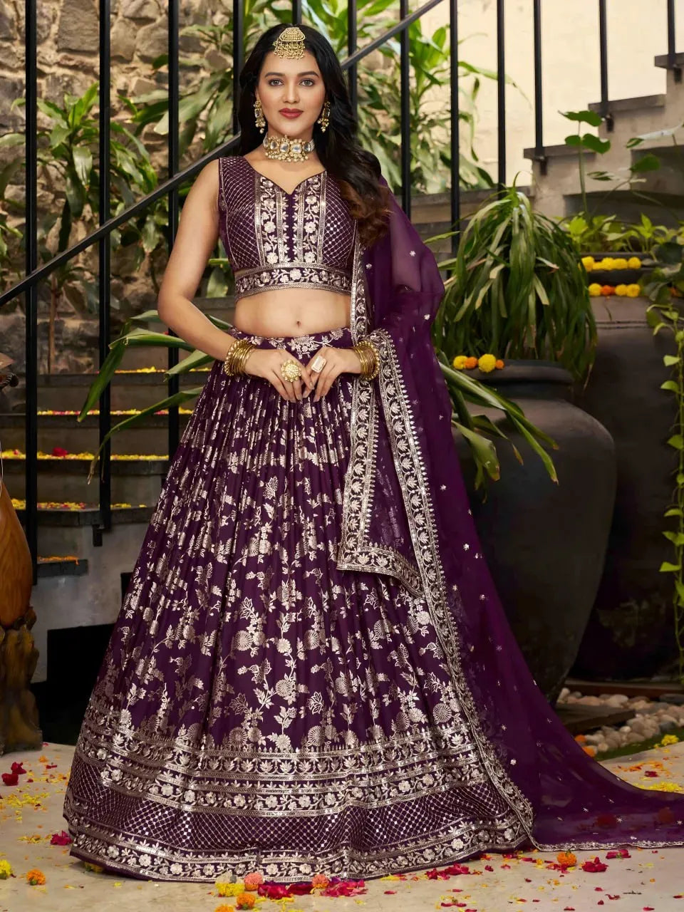 Front view of model in wine doli silk lehenga with sleeveless blouse