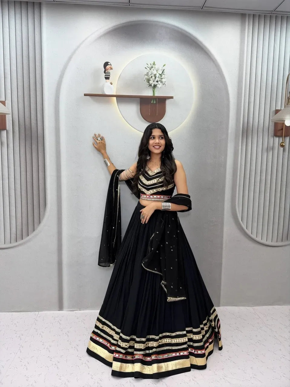 Model wearing black cotton lehenga with heavy gamthi work and mirror lace