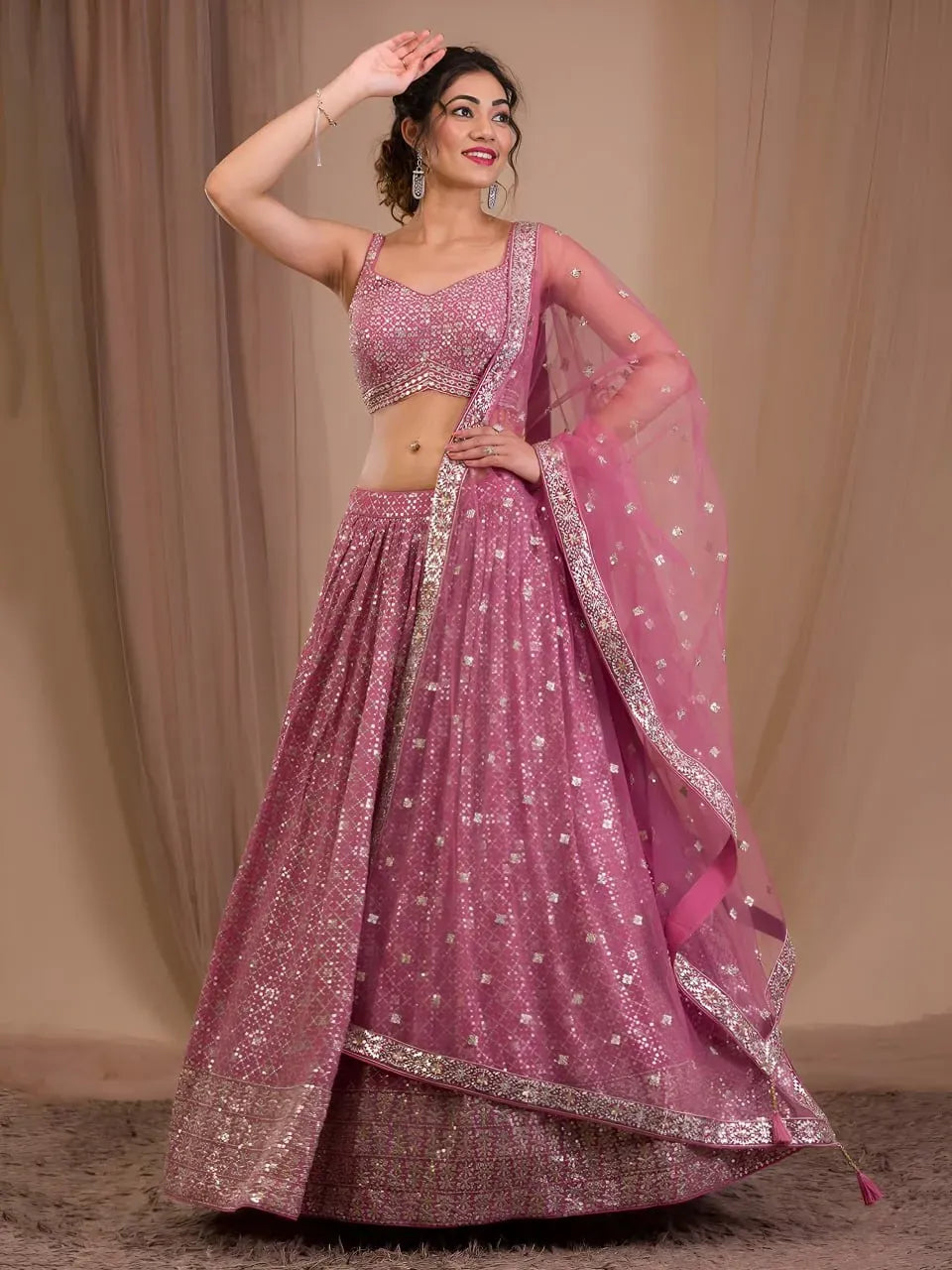 Model wearing glittering rose pink georgette lehenga choli with dupatta