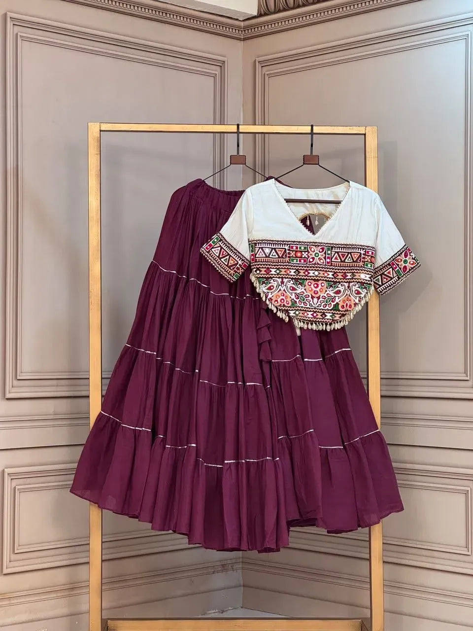 Dark purple kora cotton lehenga with white kutchi patchwork blouse on hanger