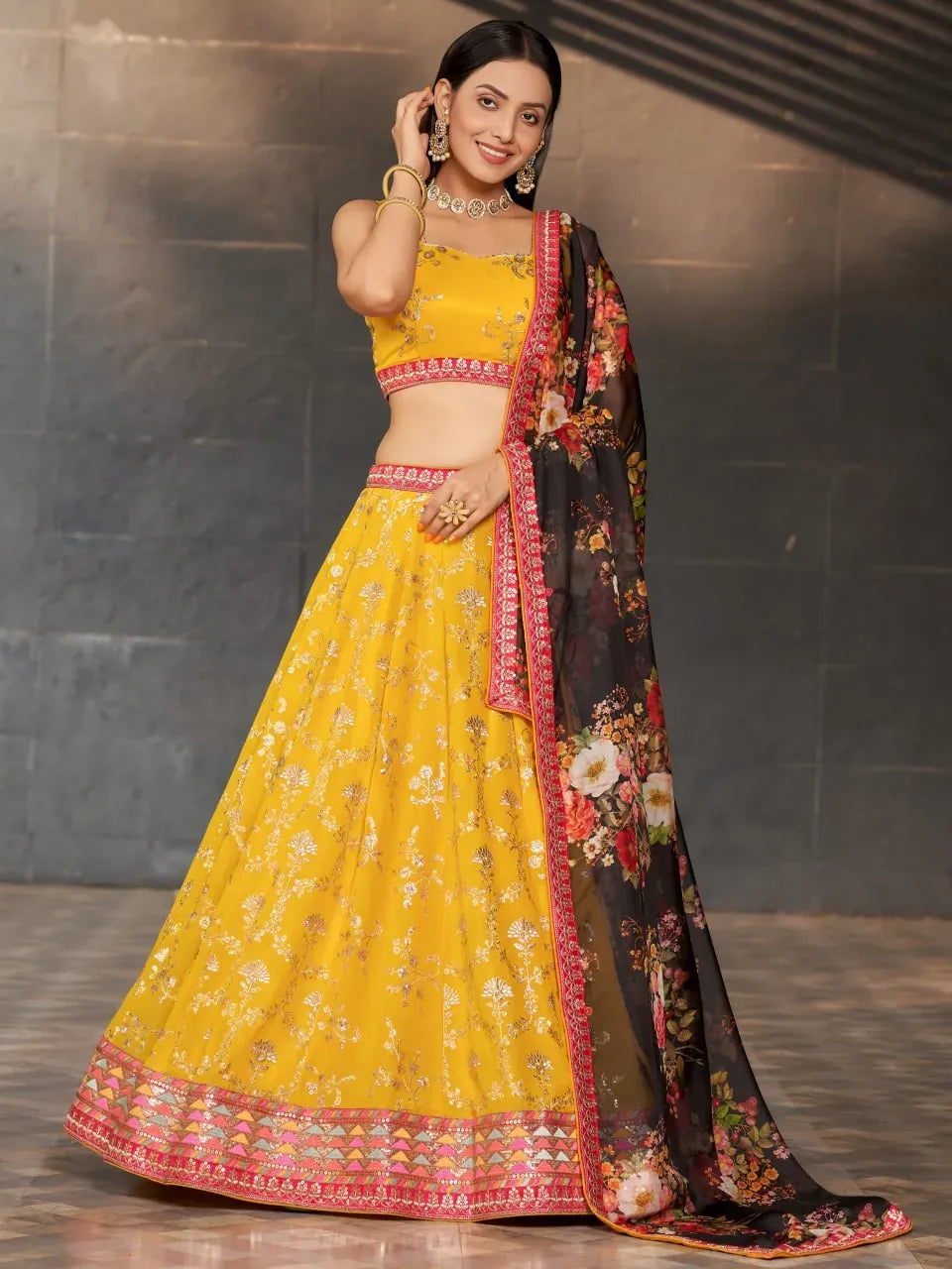 Full body front view of model in yellow marigold lehenga with black floral dupatta
