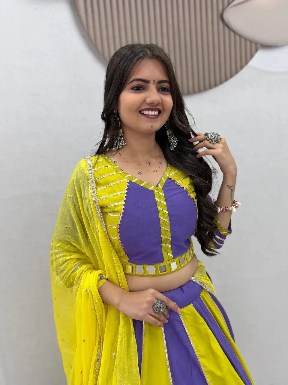 Model wearing yellow and purple cotton lehenga choli with mirror work