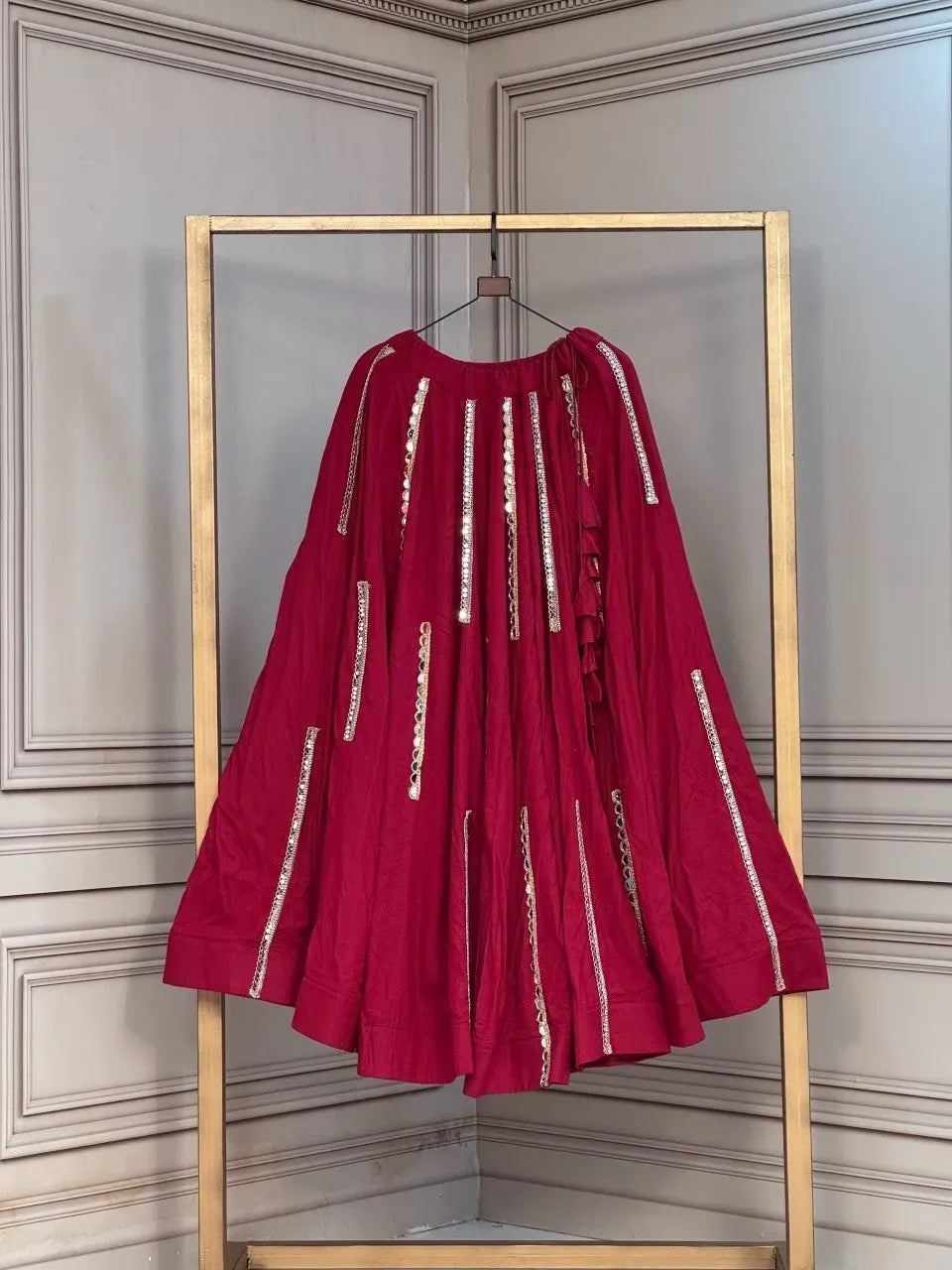 Maroon rayon lehenga with mirror lace work hanging on a rack