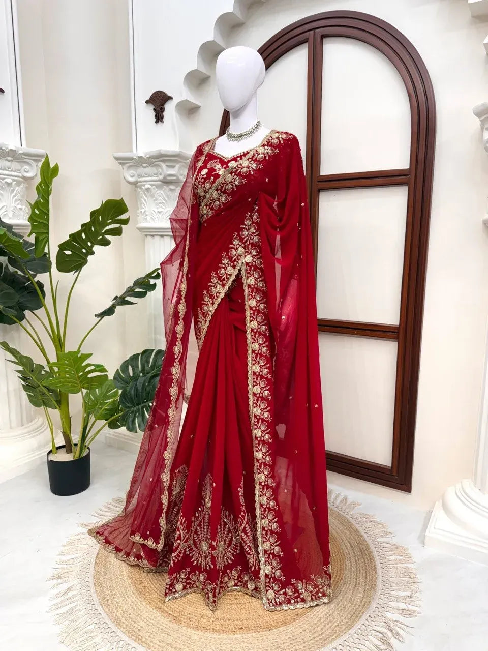 Mannequin wearing red designer saree with heavy gold thread and sequence work