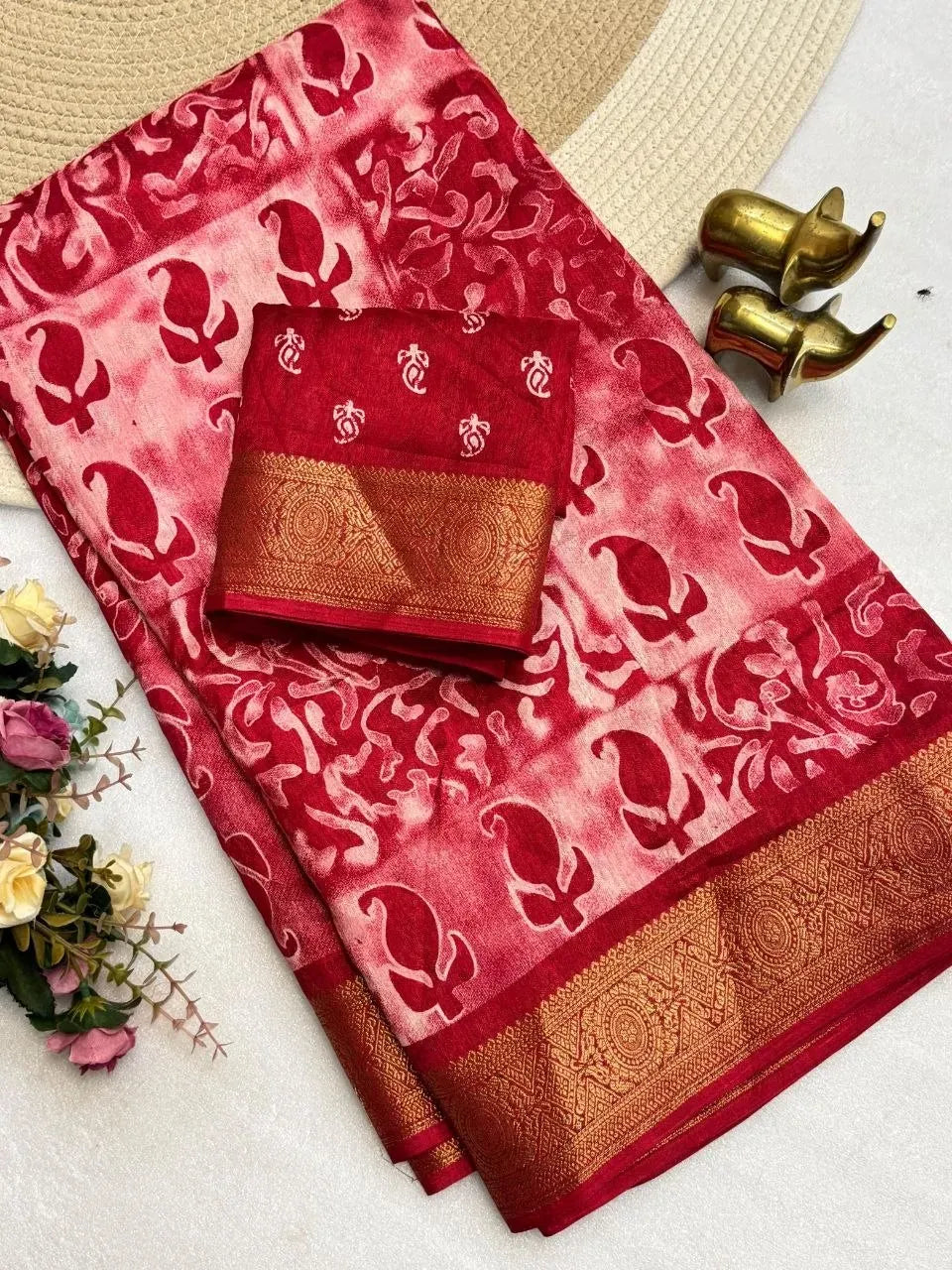 Red Dola silk saree with floral print and golden weaving border flat lay