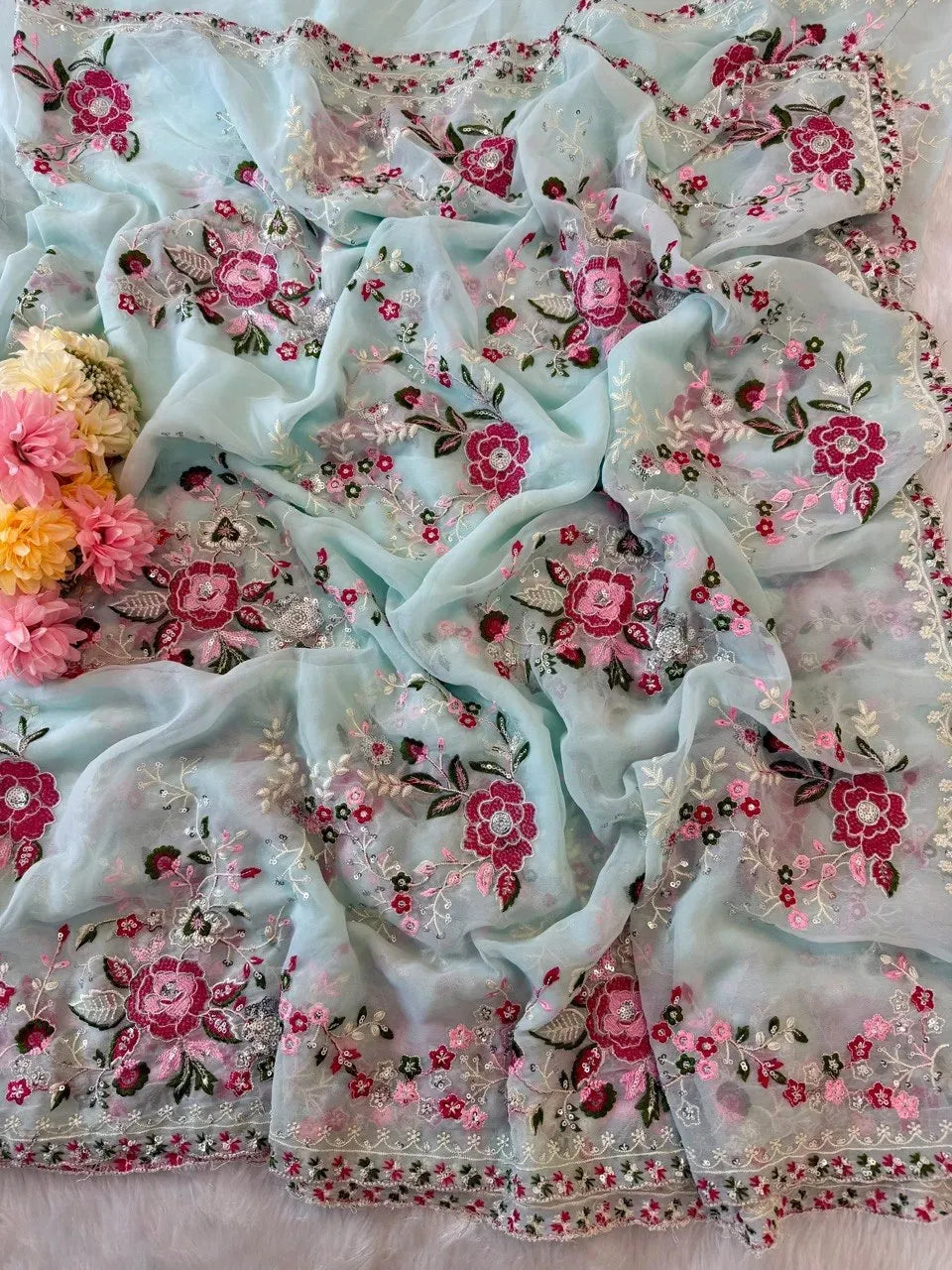 Light blue georgette saree fabric spread flat with colorful floral thread work