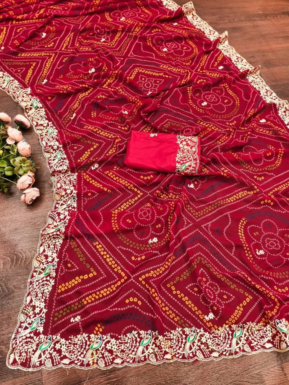 Full flat lay of red georgette bandhani saree with cut-work border