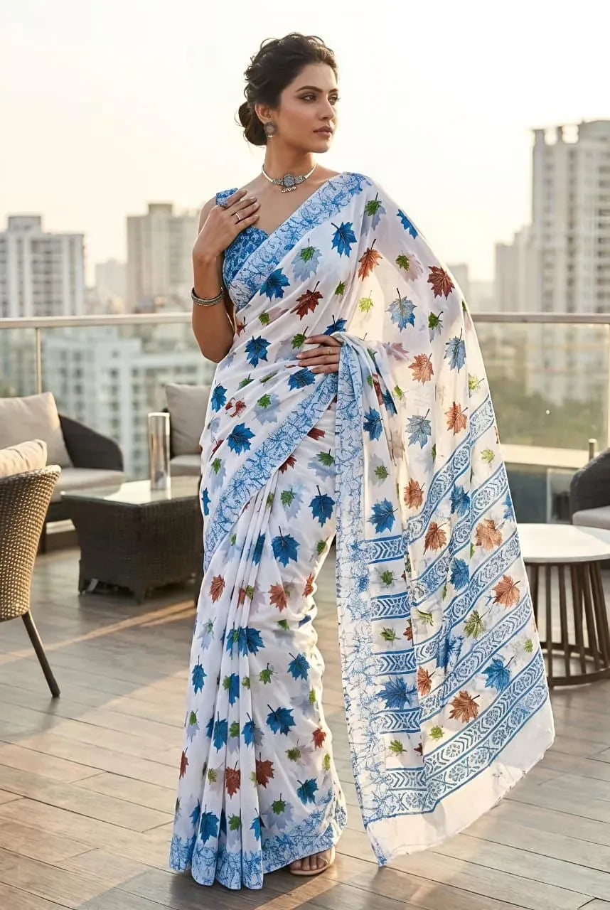 Model wearing white and blue soft georgette saree with leaf print standing on rooftop terrace