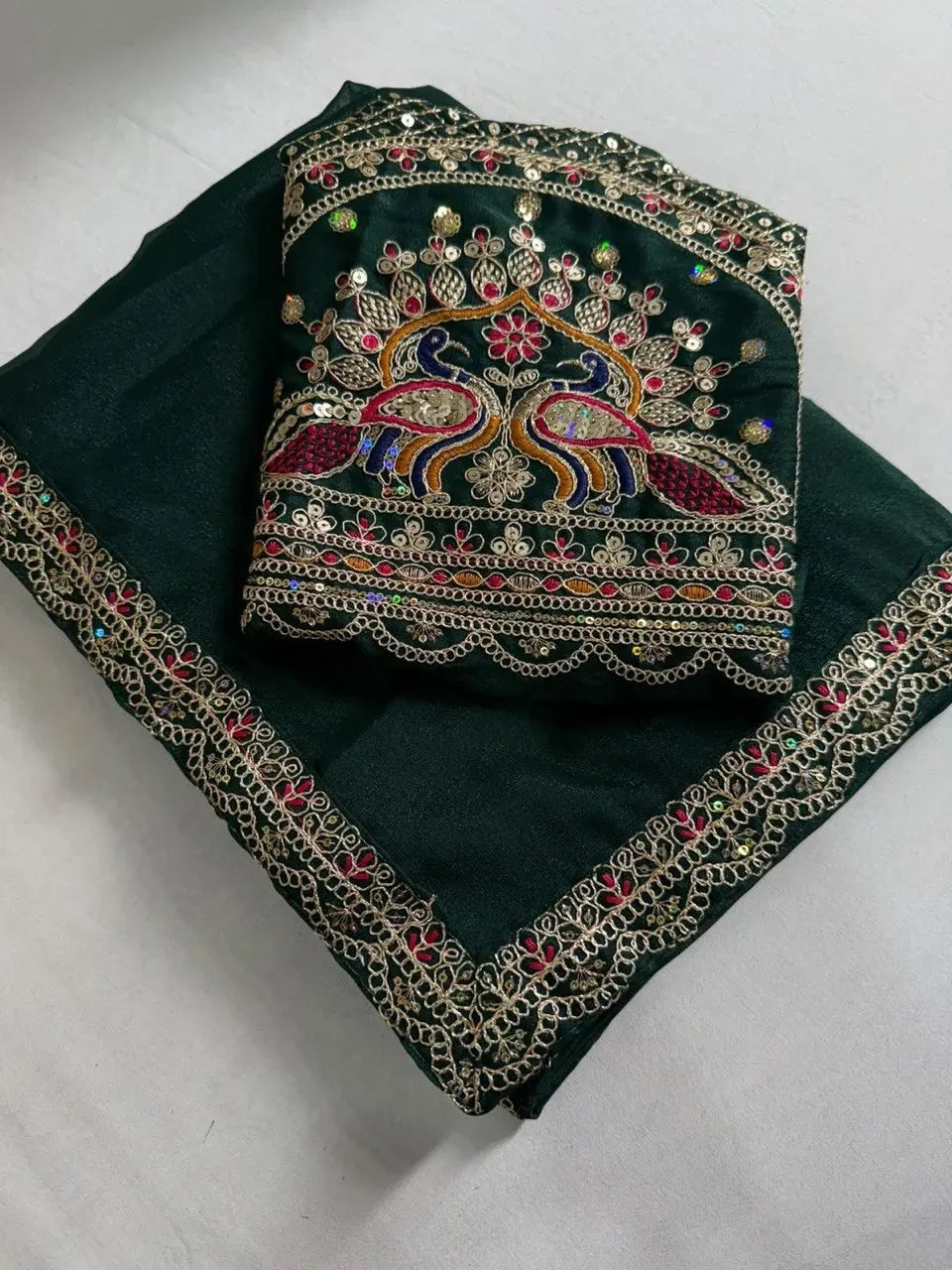 Dark green georgette saree with heavy sequence work and peacock motif blouse piece