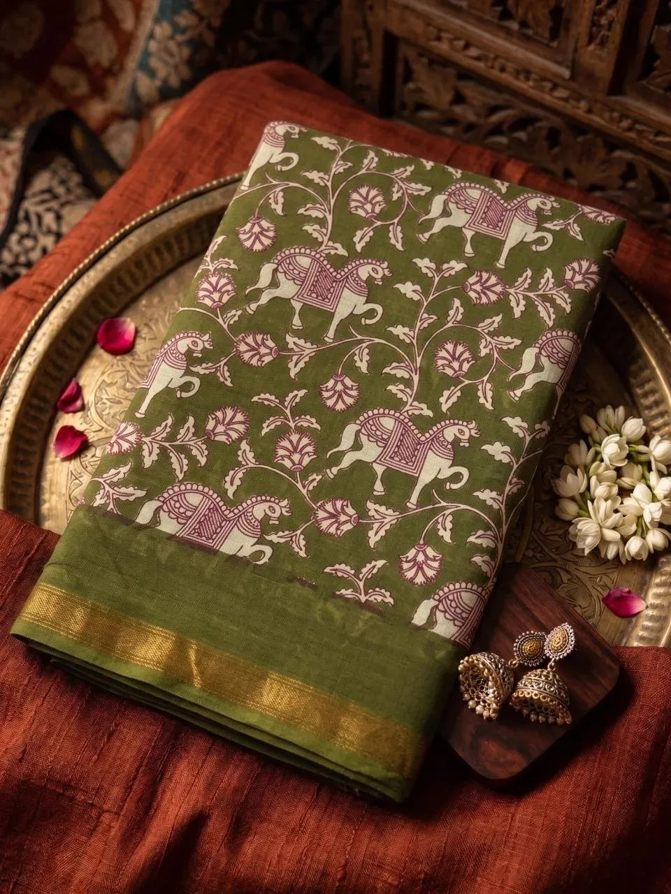 Folded olive green cotton saree with elephant and floral block print on brass tray