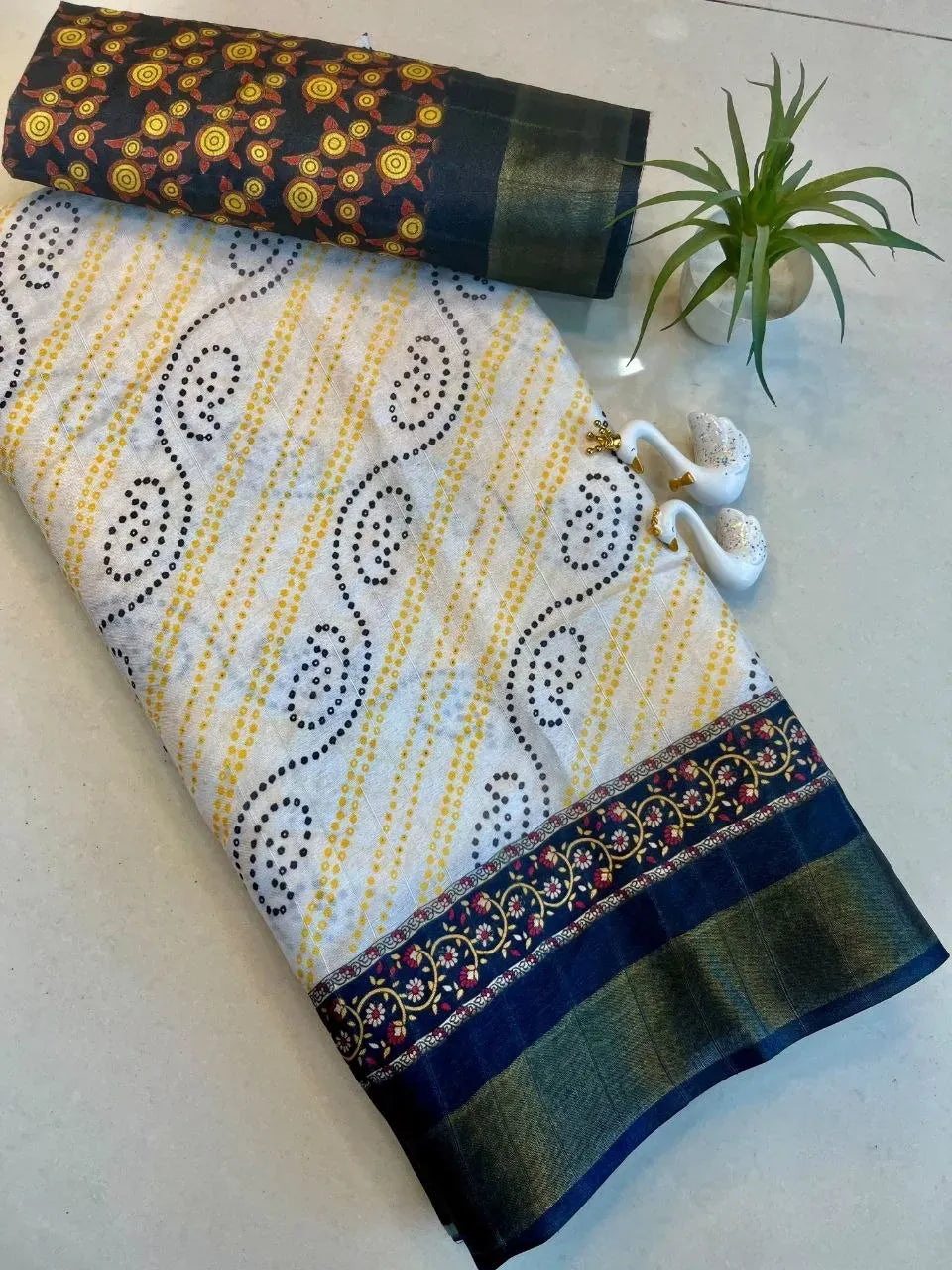 Folded white and yellow digital print handloom silk saree with dark border