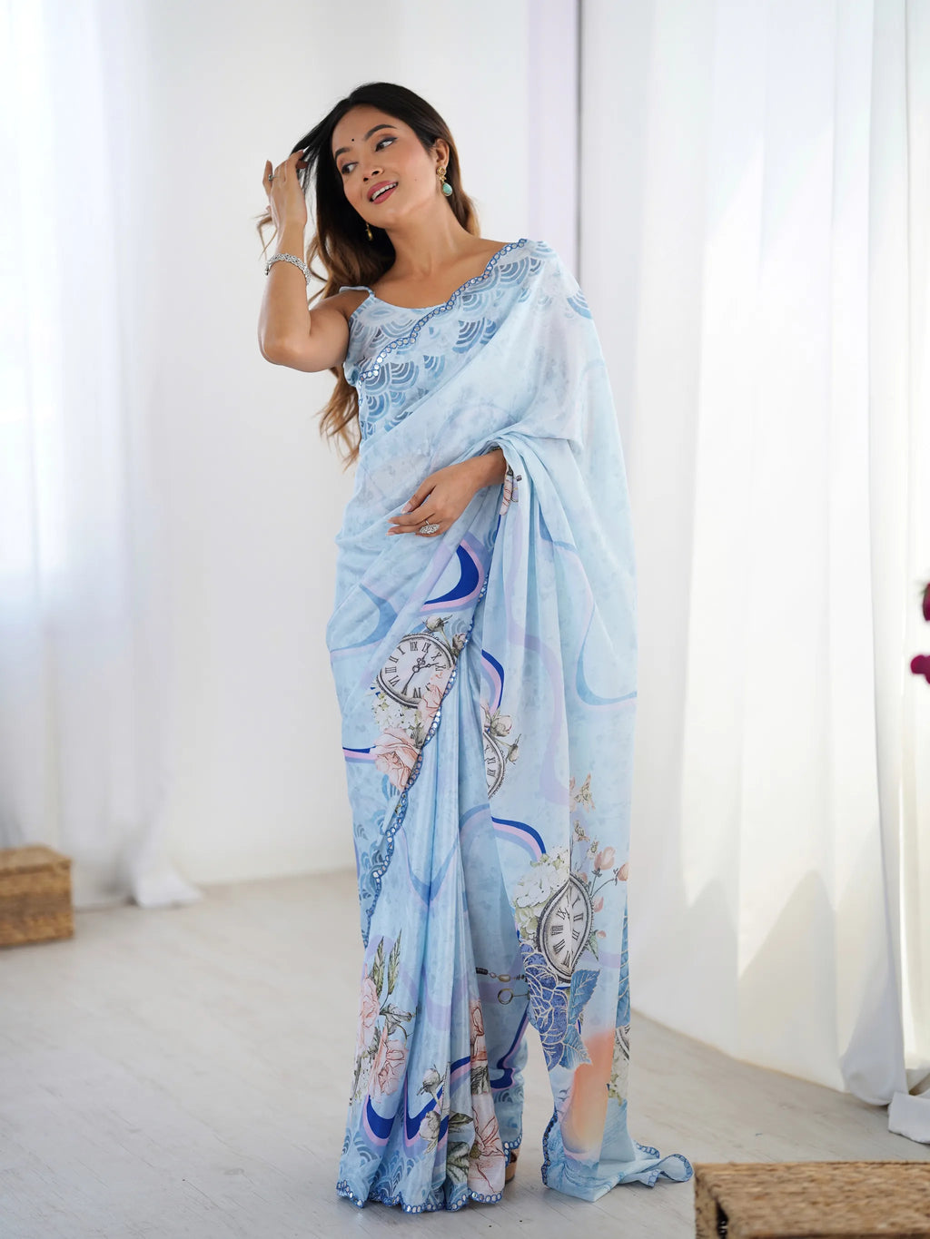 Model posing in light blue printed chinnon saree with mirror work border