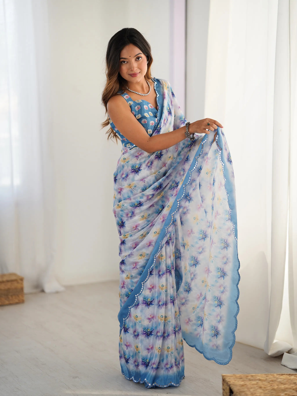 Model wearing blue floral printed chinnon saree with mirror work border