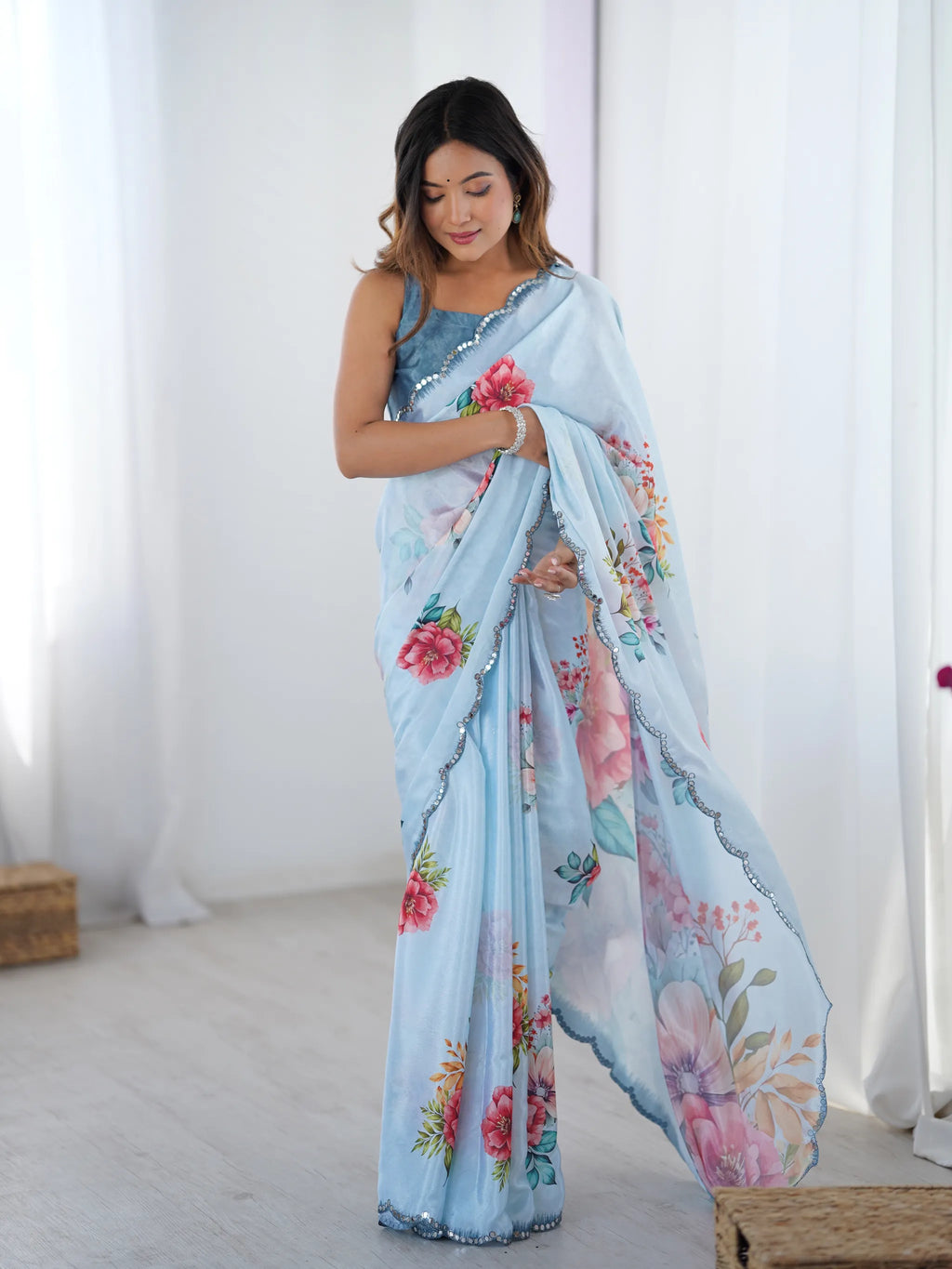 Model wearing light blue floral chinnon saree with mirror lace border