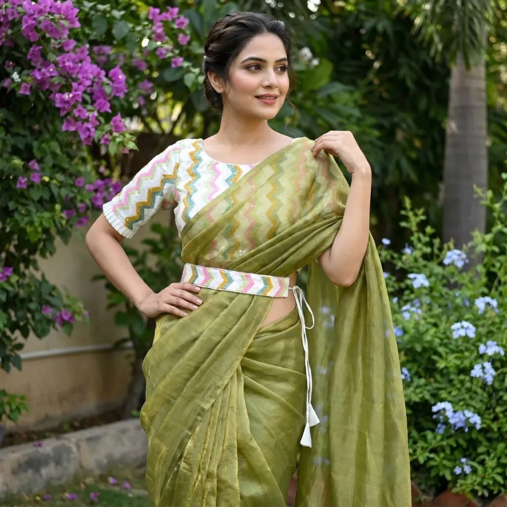 Woman posing outdoors wearing green space silk saree with embroidered blouse and belt