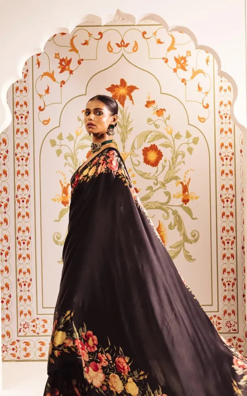 Model standing facing forward in black floral digital print satin saree