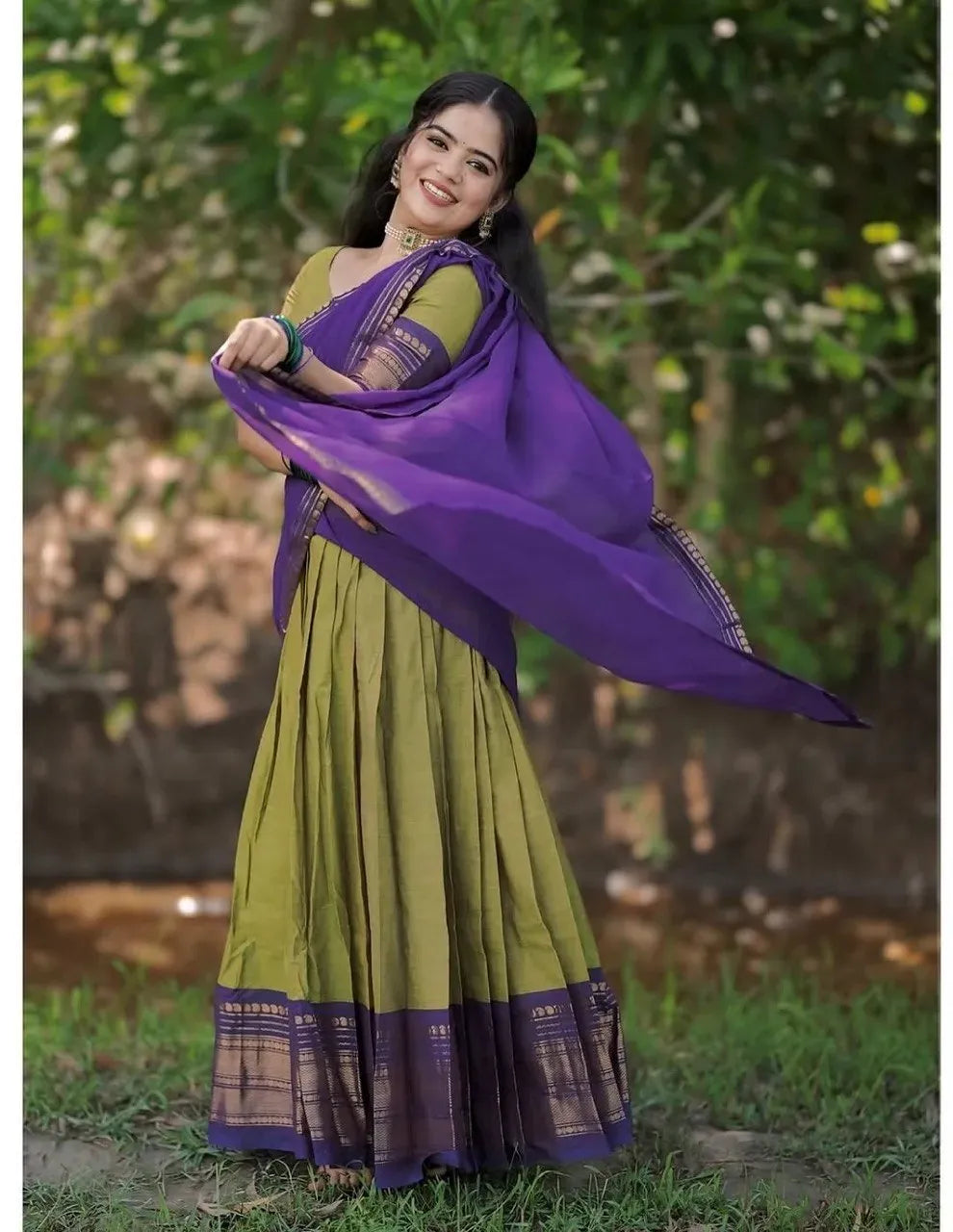 Model wearing green and purple kanjivaram silk lehenga outdoor