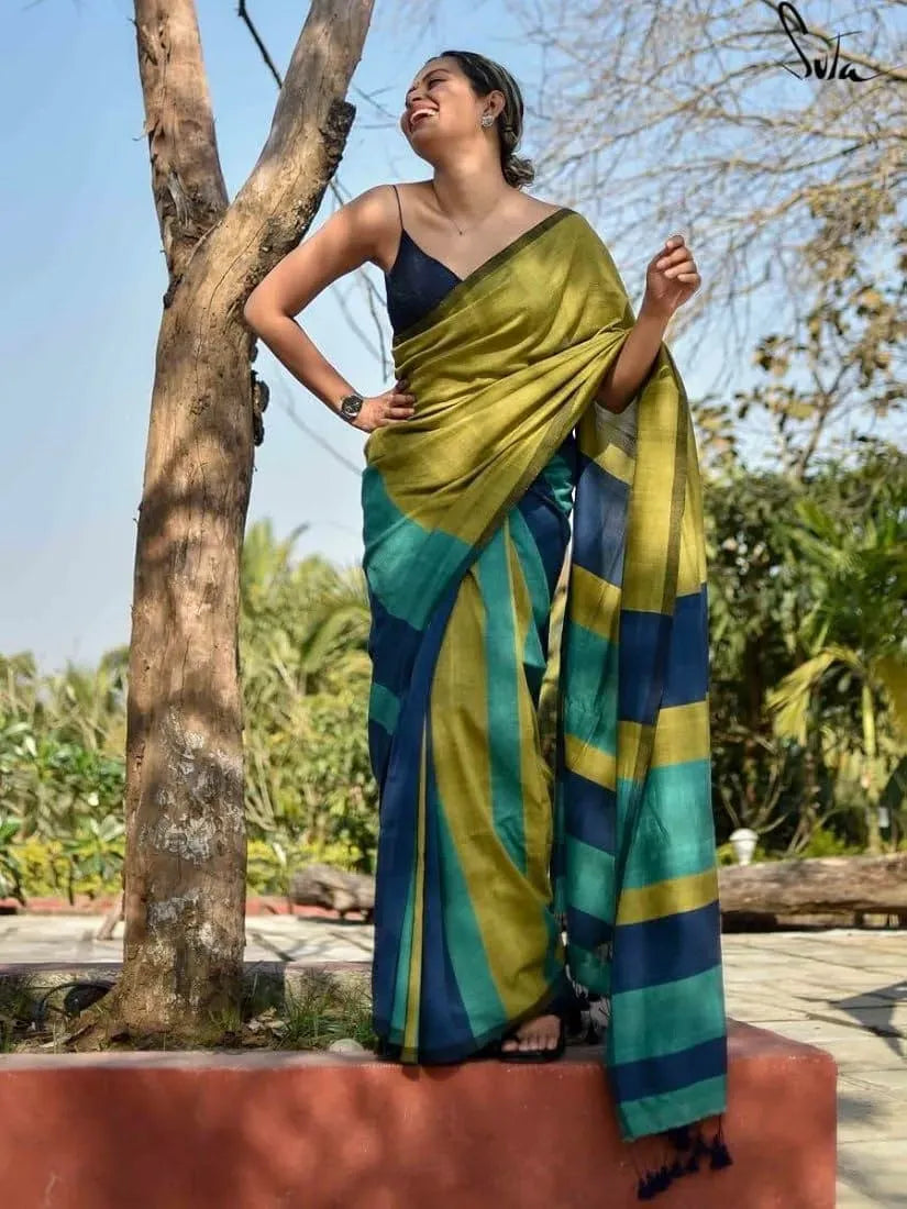 Model smiling in a green and blue striped khadi cotton saree outdoors