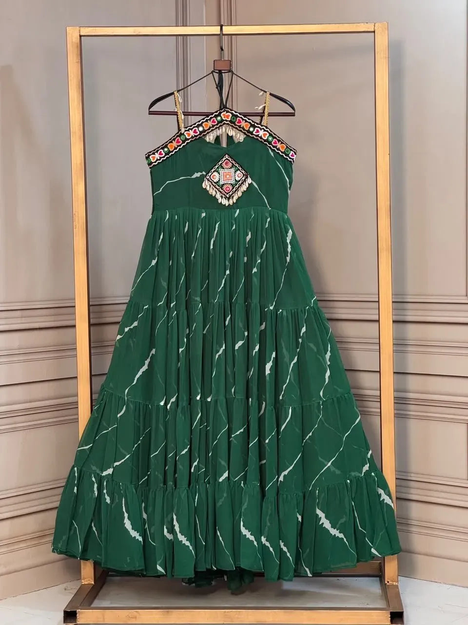 Green laheriya print gown with kutchi patchwork on a hanger