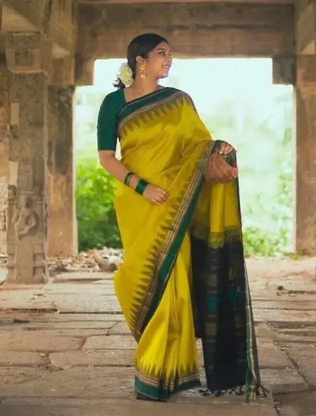 Full body view of model standing in yellow and green lichi silk saree