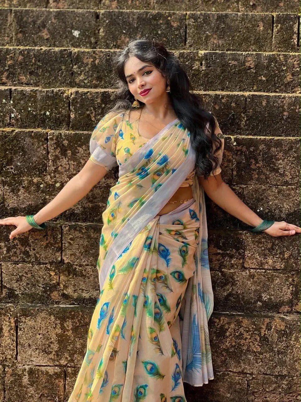 Model standing against stone wall showcasing full length of printed linen cotton saree