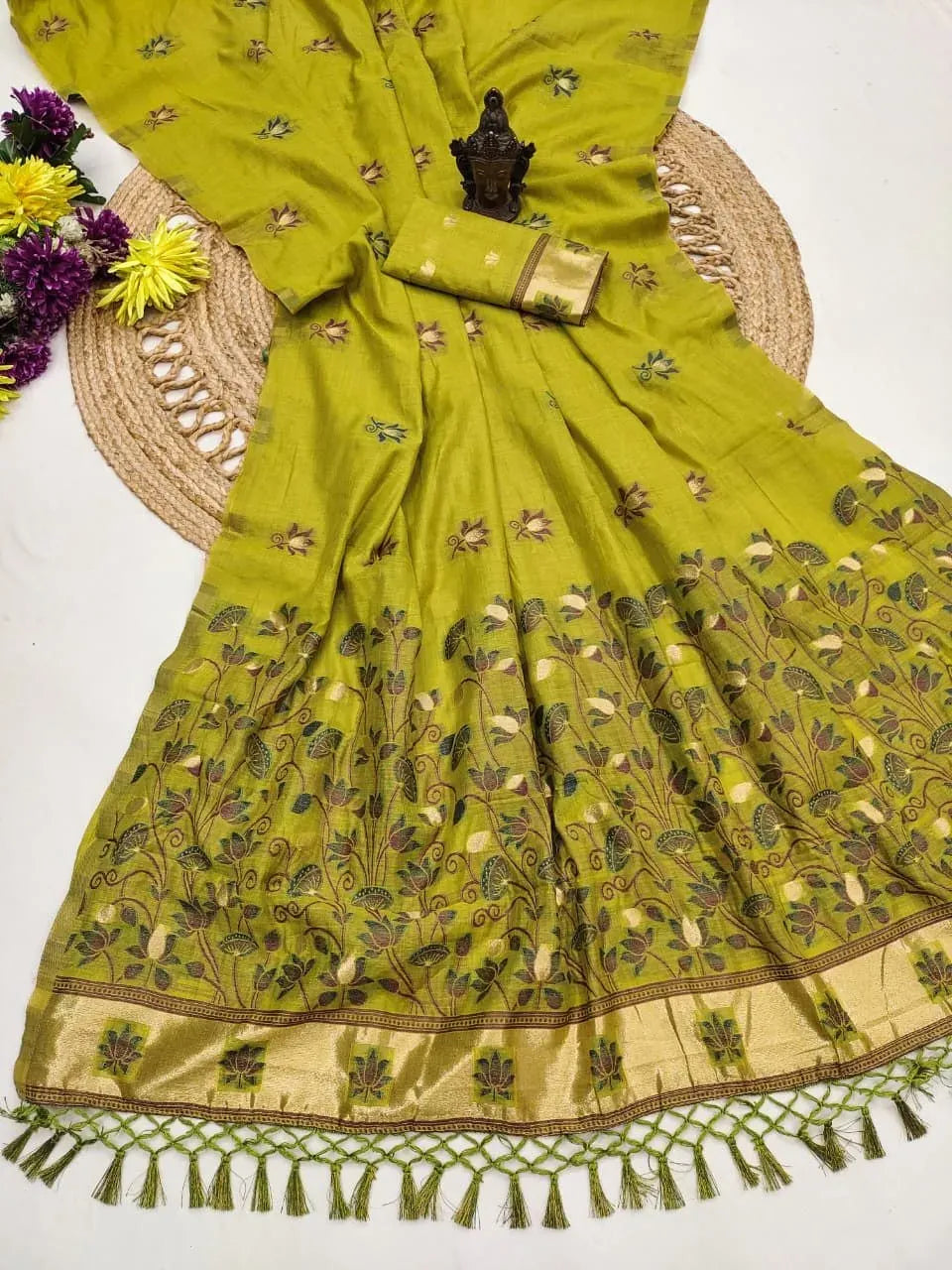 Olive green soft mul cotton saree with zari butta and pallu tassels laid out flat