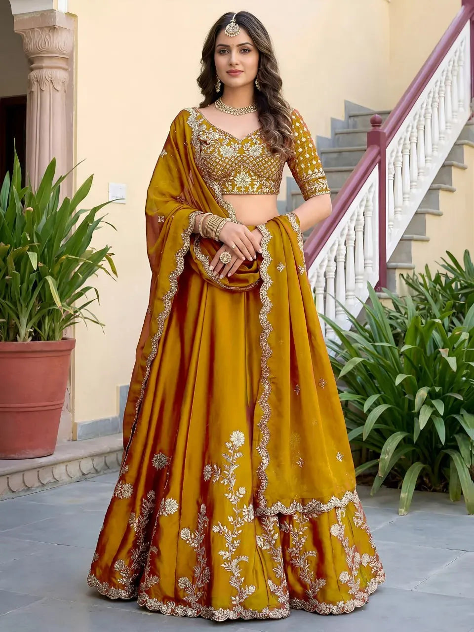 Full body front view of model wearing mustard yellow gold floral embroidered lehenga and dupatta