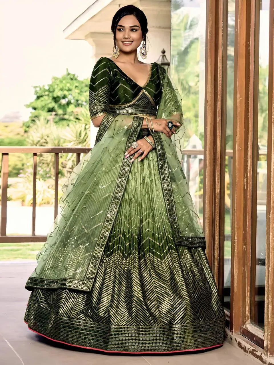 Full body shot of model wearing olive green ombre lehenga choli with net dupatta