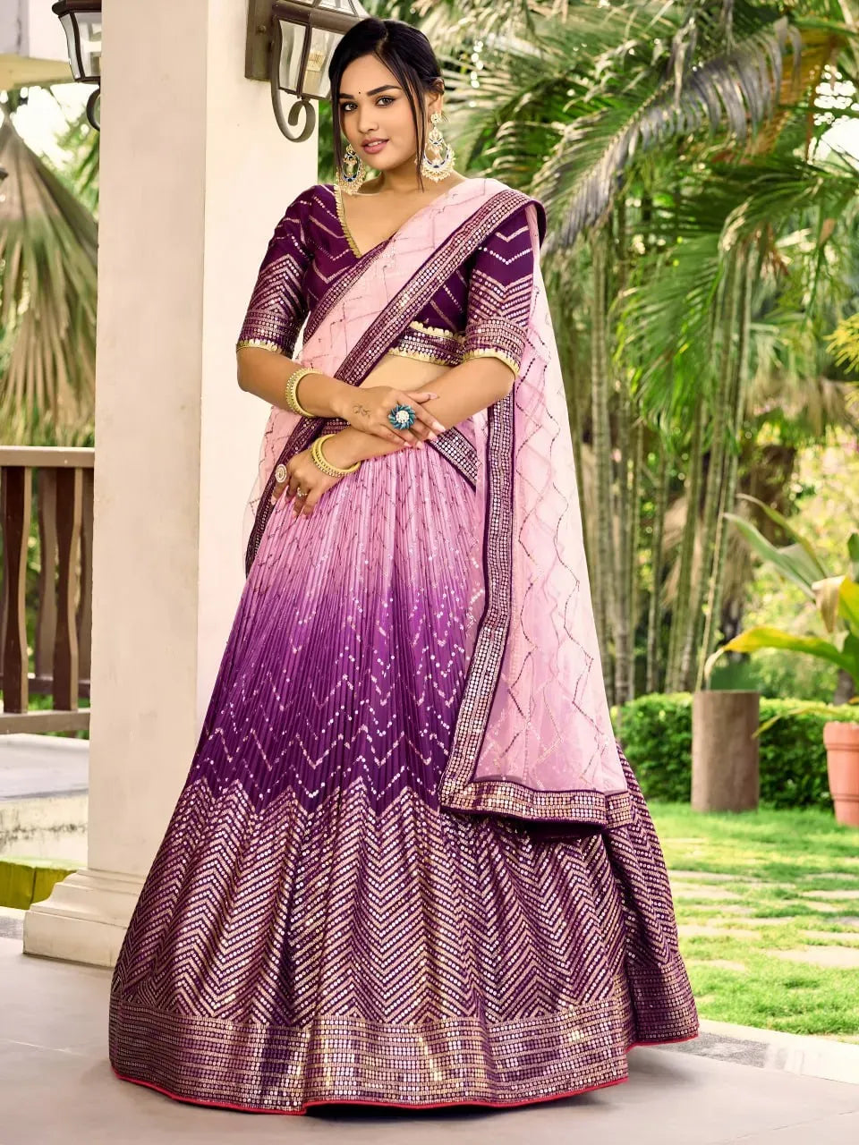 Full body shot of model wearing royal purple ombre lehenga choli with pink dupatta