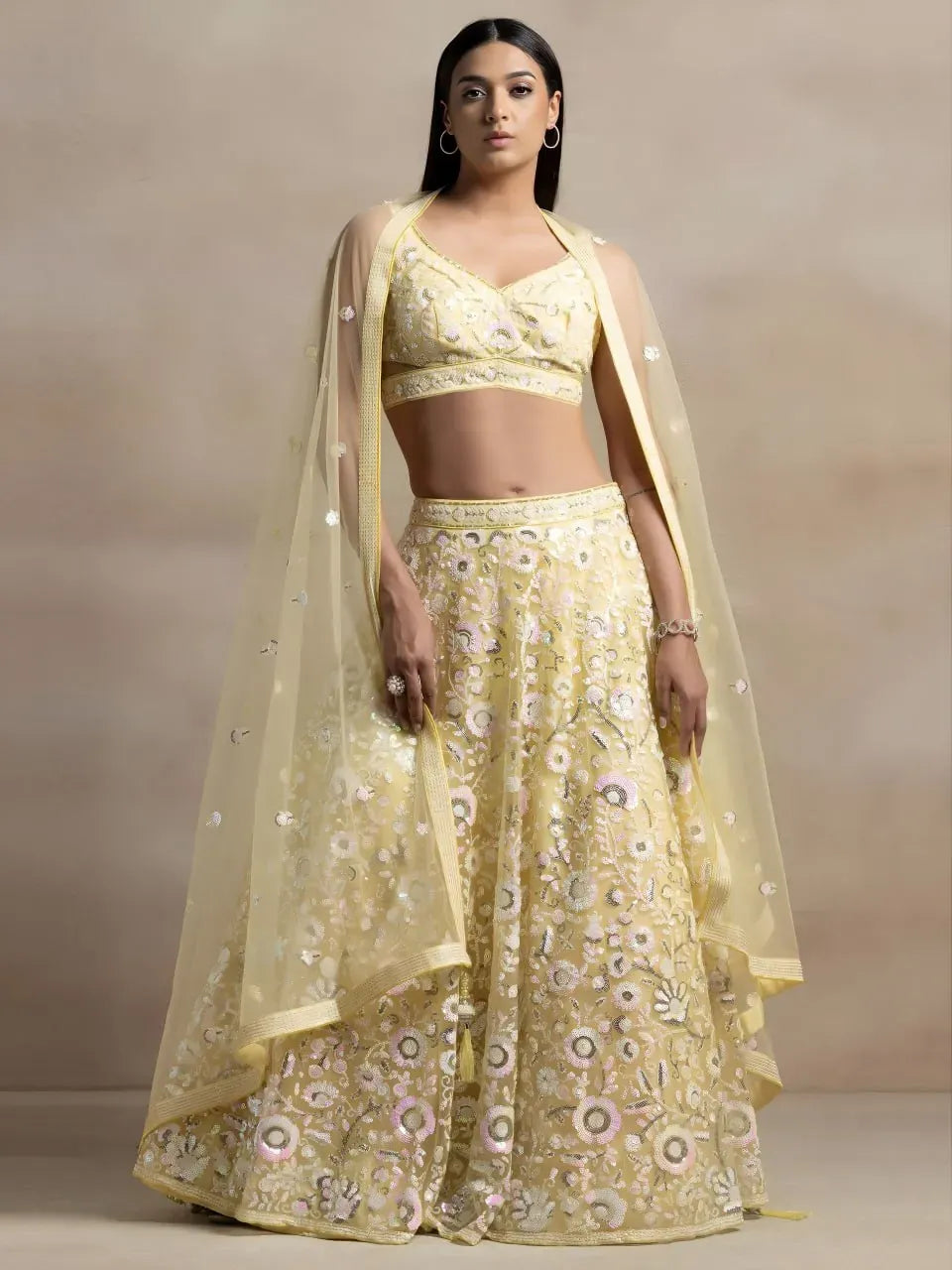 Model wearing pastel yellow floral sequins embroidered lehenga choli with dupatta