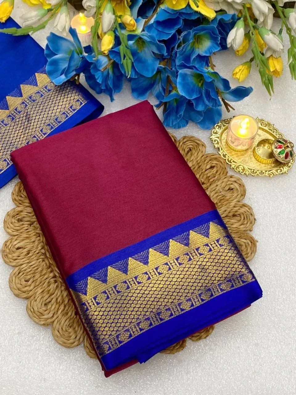 Folded maroon cotton silk saree with blue and gold zari border