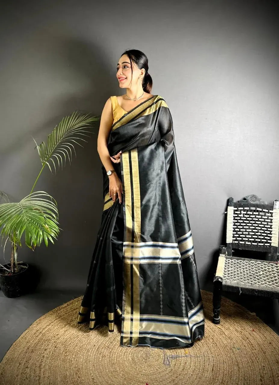 Model wearing black raw silk saree with gold weaving work