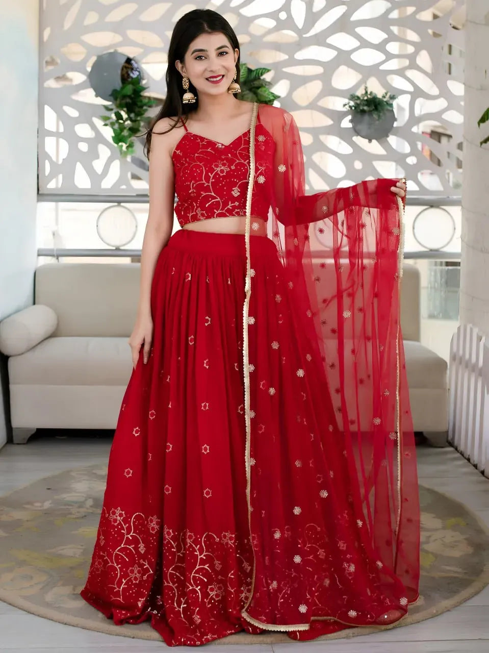 Front view of model in red festive lehenga with golden sequin work