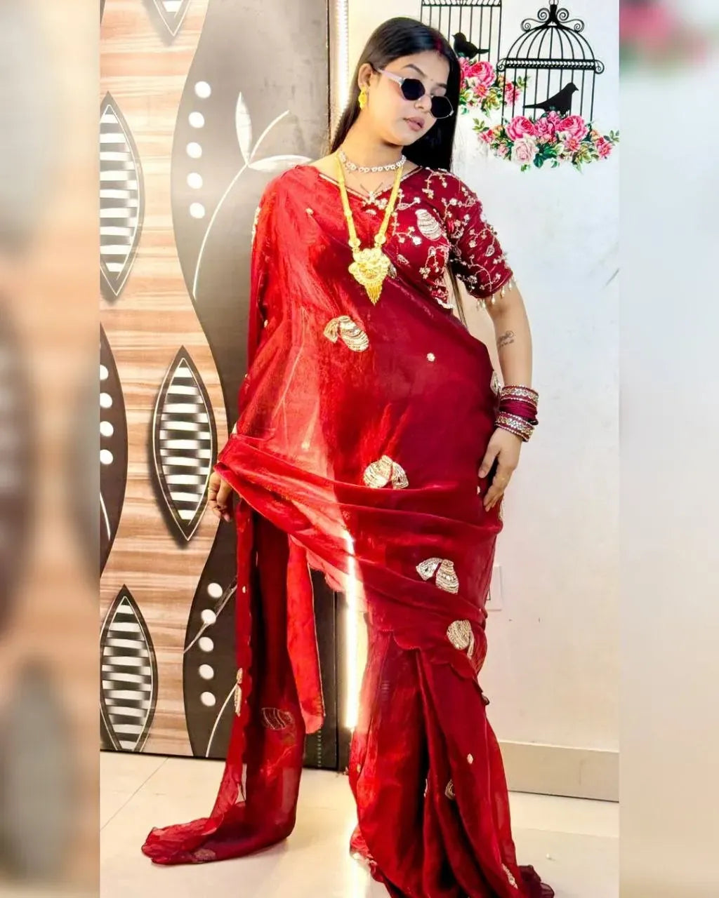 Full length view of a model posing in a traditional red designer saree