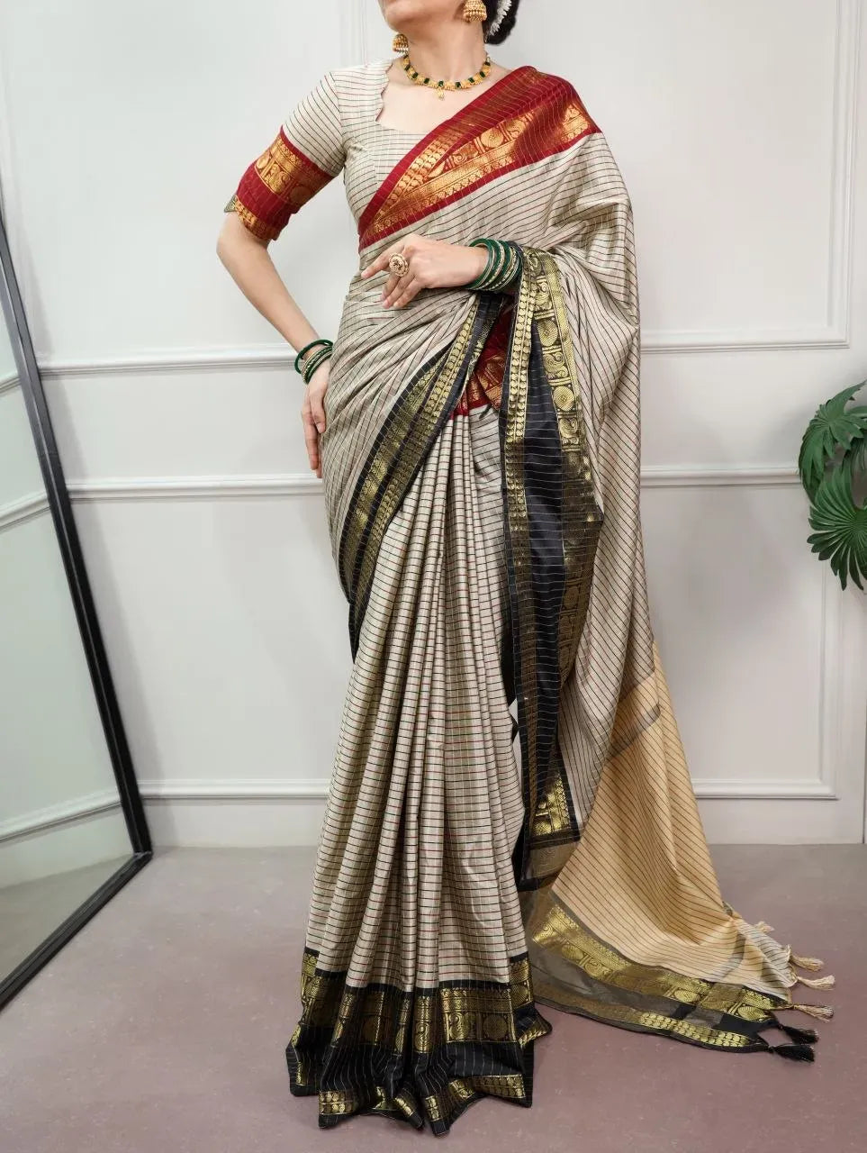 Full body front view of model in traditional silk saree with ornate zari border