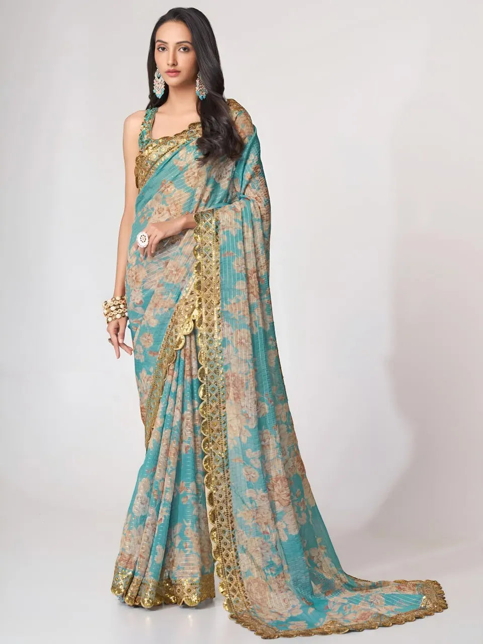 Full body front view of model wearing sky blue floral organza saree with gold scalloped border