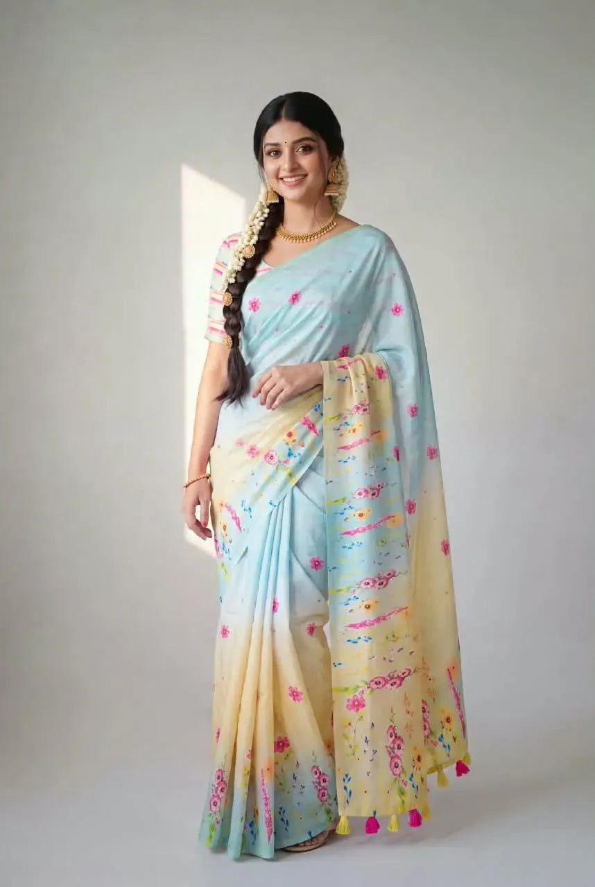 Woman wearing light blue and yellow soft linen saree with floral print and aari mirror work