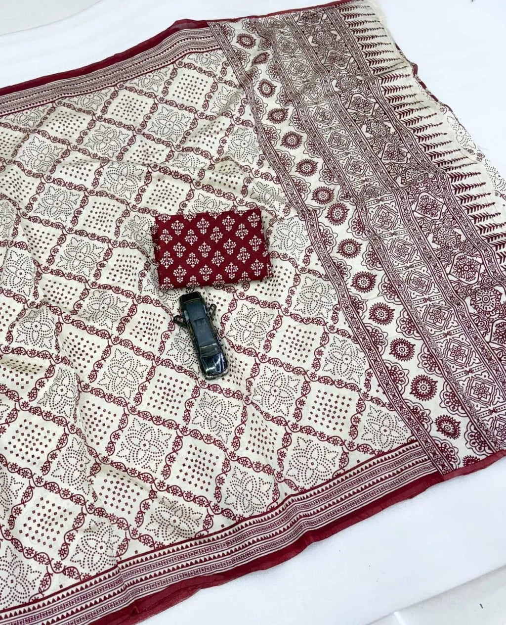 Off-white and maroon soft mal chanderi cotton ajrakh print saree flat lay